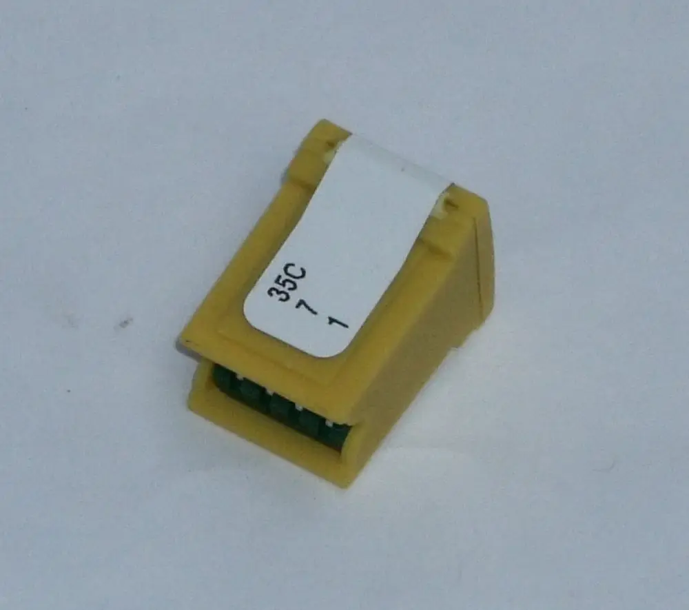 Gelber Kodierstecker von Daikin mit eckiger Form und einem weißen Aufkleber, der Zahlen enthält. Der Stecker ist für die Nutzung an bestimmten Daikin-Geräten konzipiert.